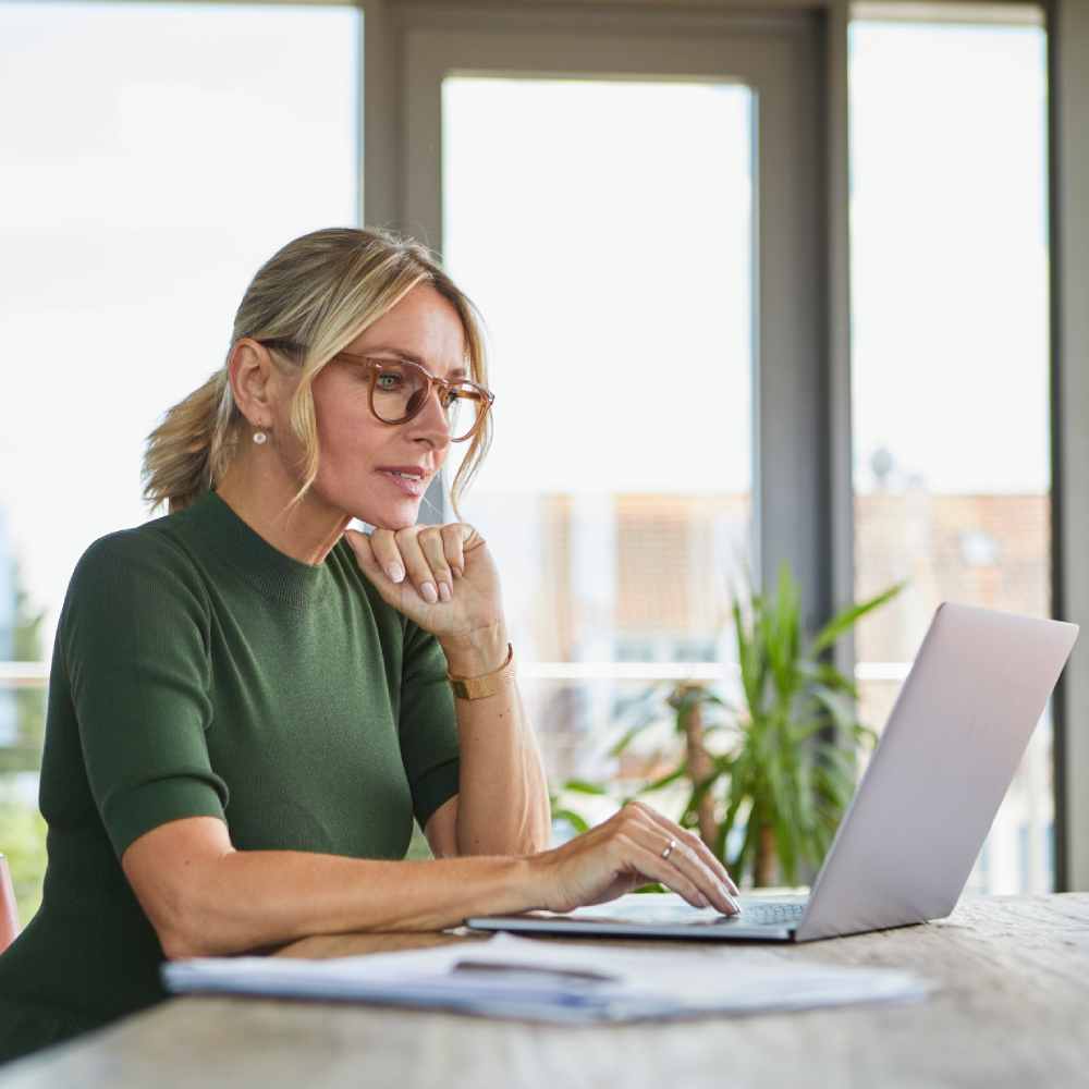 Mature woman using laptop on table at home