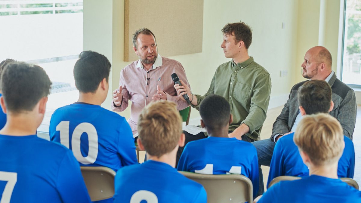 Fathers talking to young football players