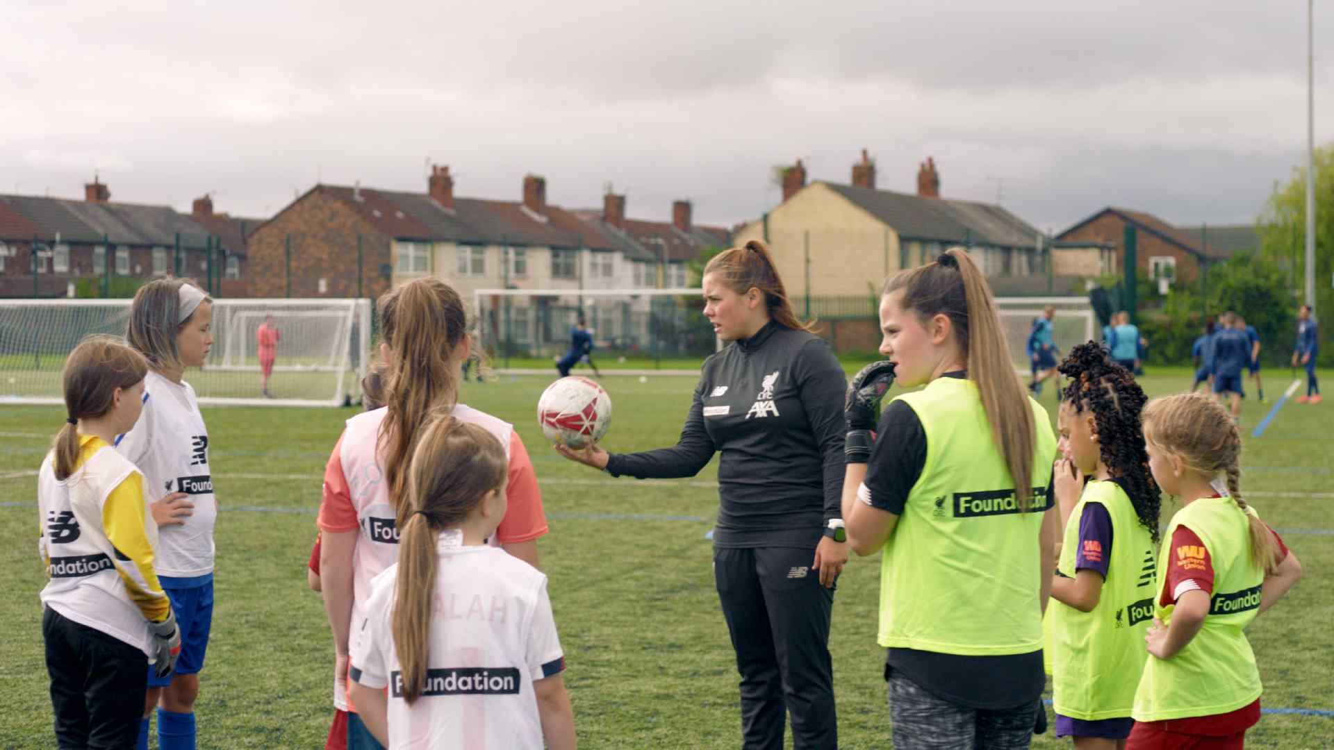 Liverpool Football Club Foundation coach talking to young girls as part of the Head Coaches programme in partnership with AXA UK