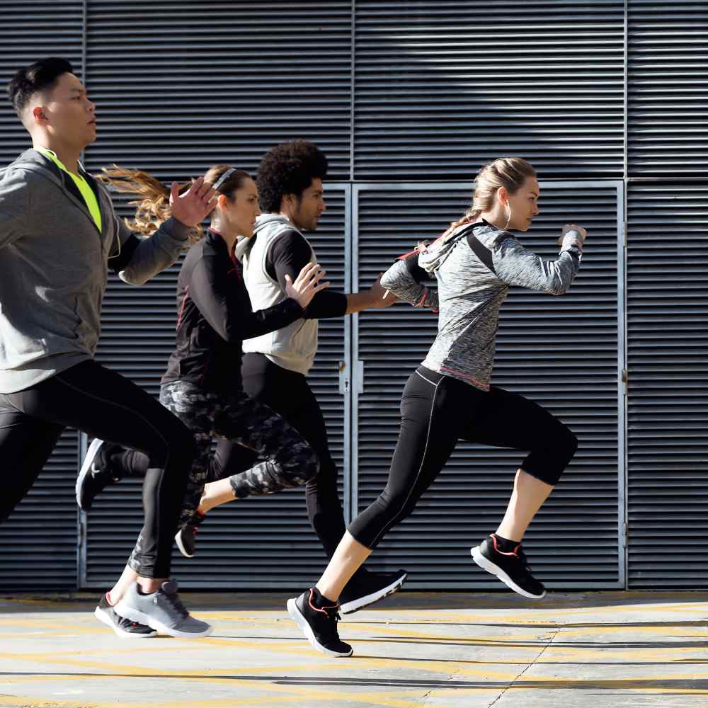 Outdoor portrait of group of friends running in the city