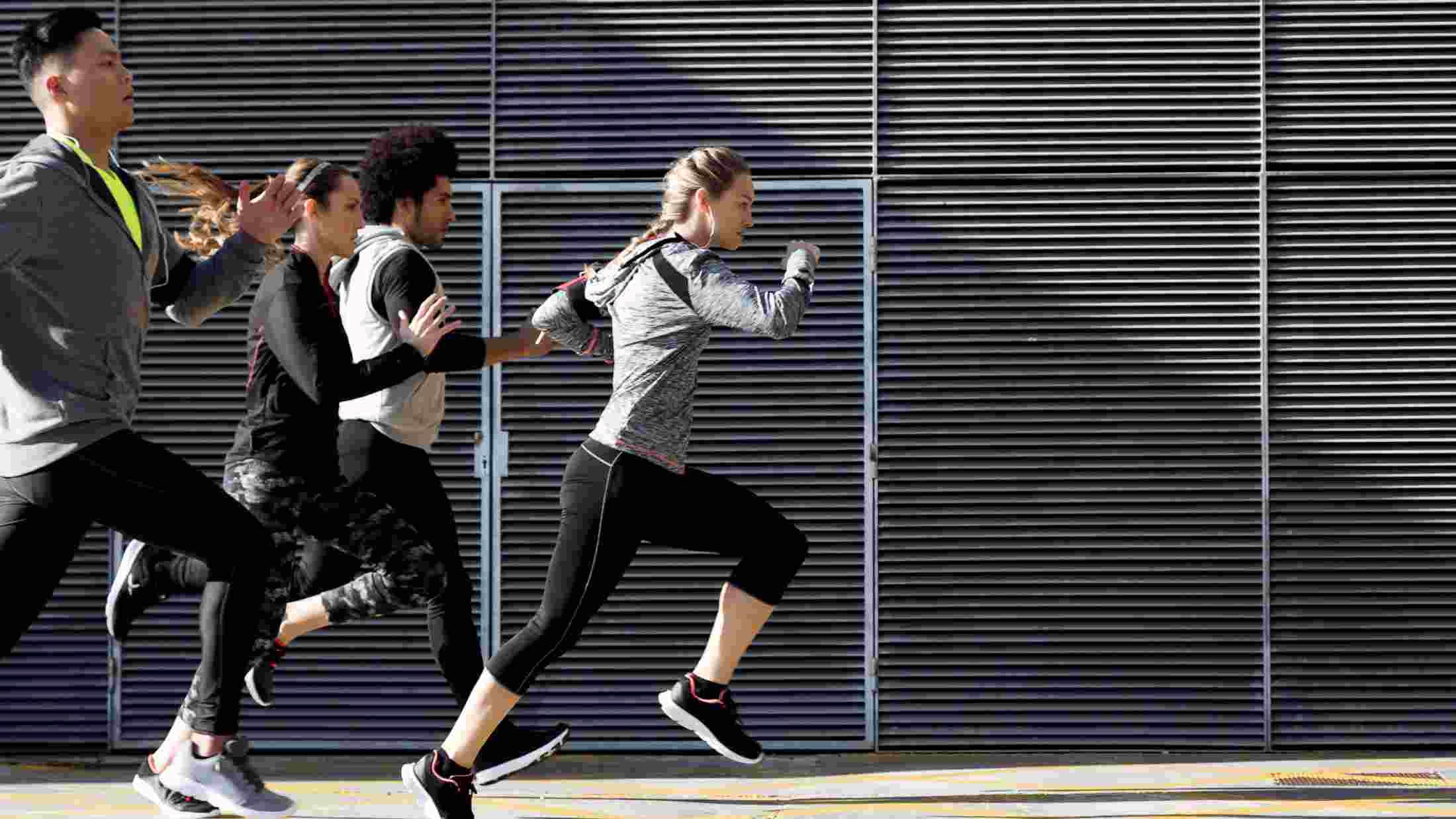 Outdoor portrait of group of friends running in the city