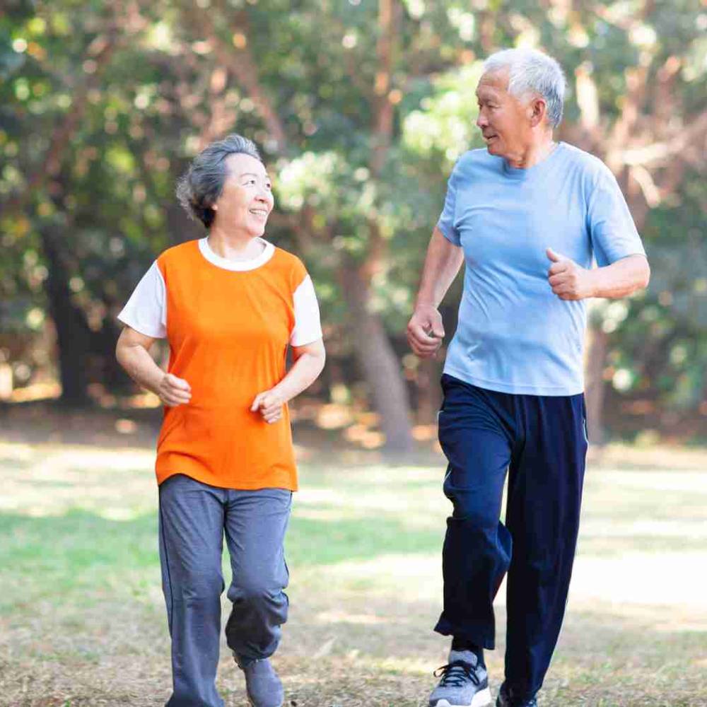Retired Asian couple running in park