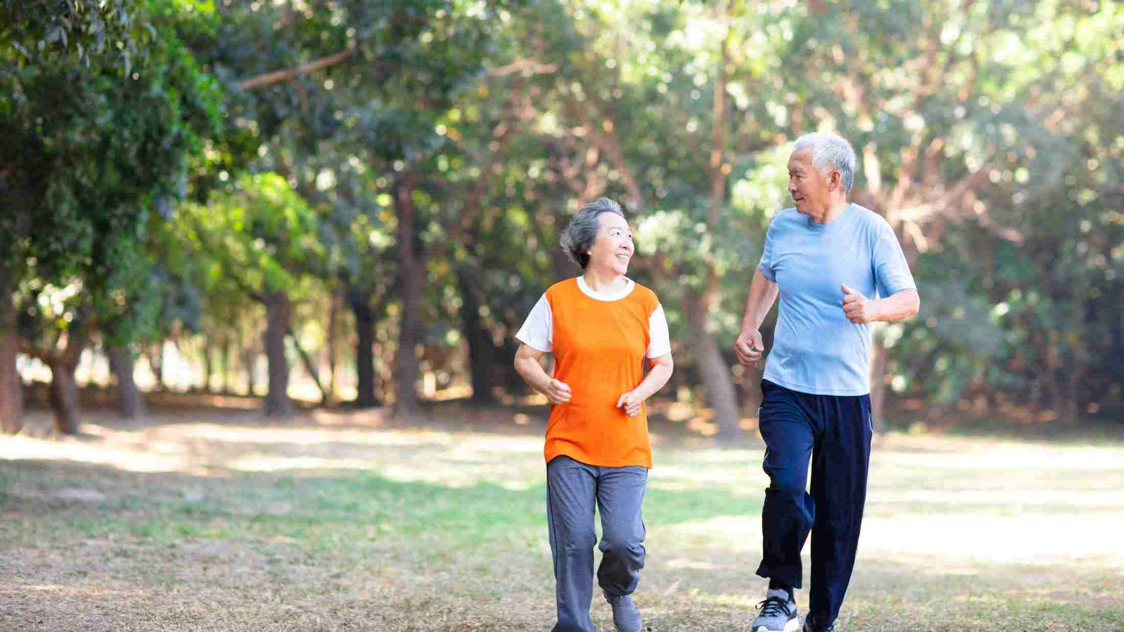 Retired Asian couple running in park