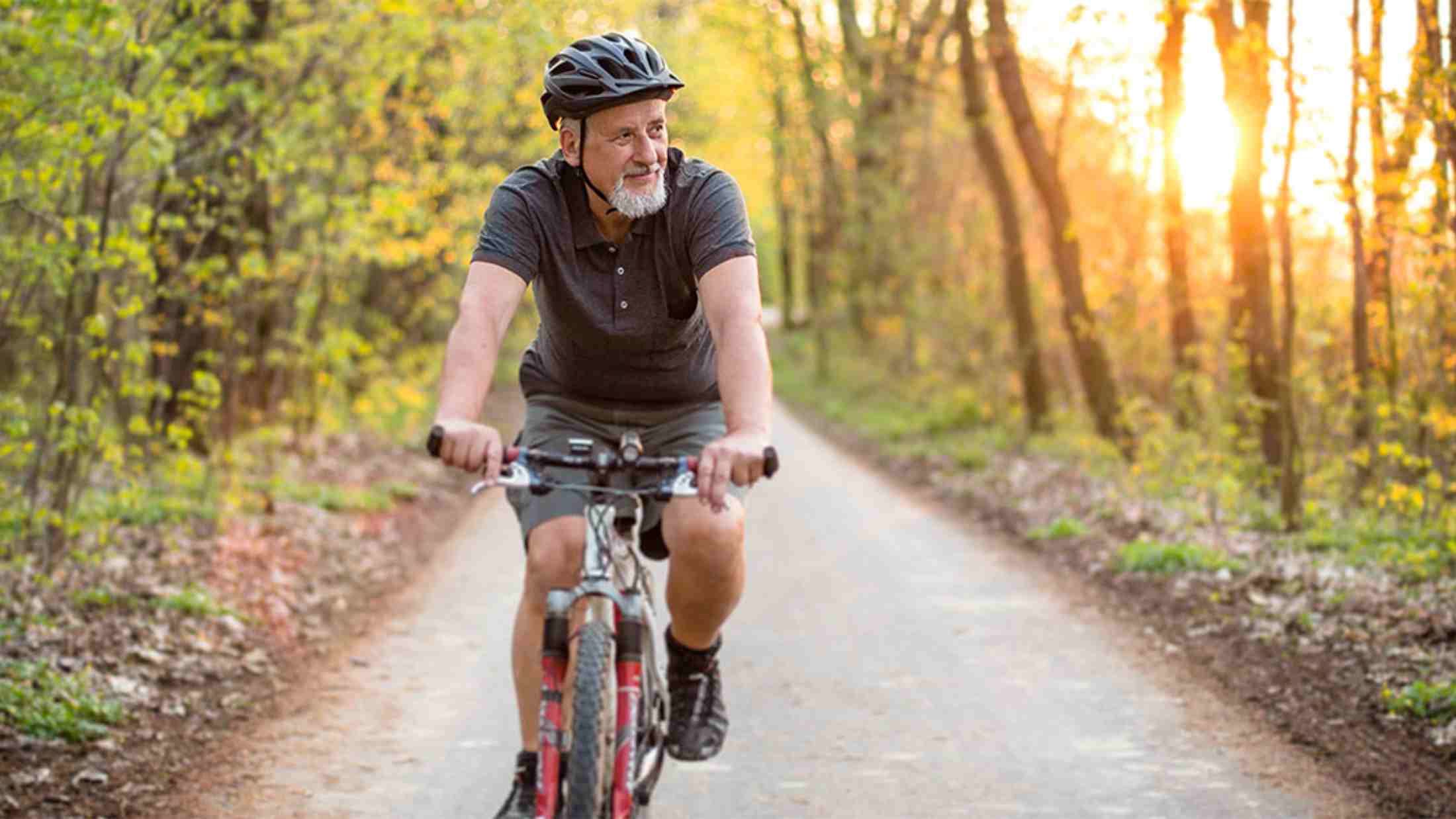 Senior man cycling on a country road