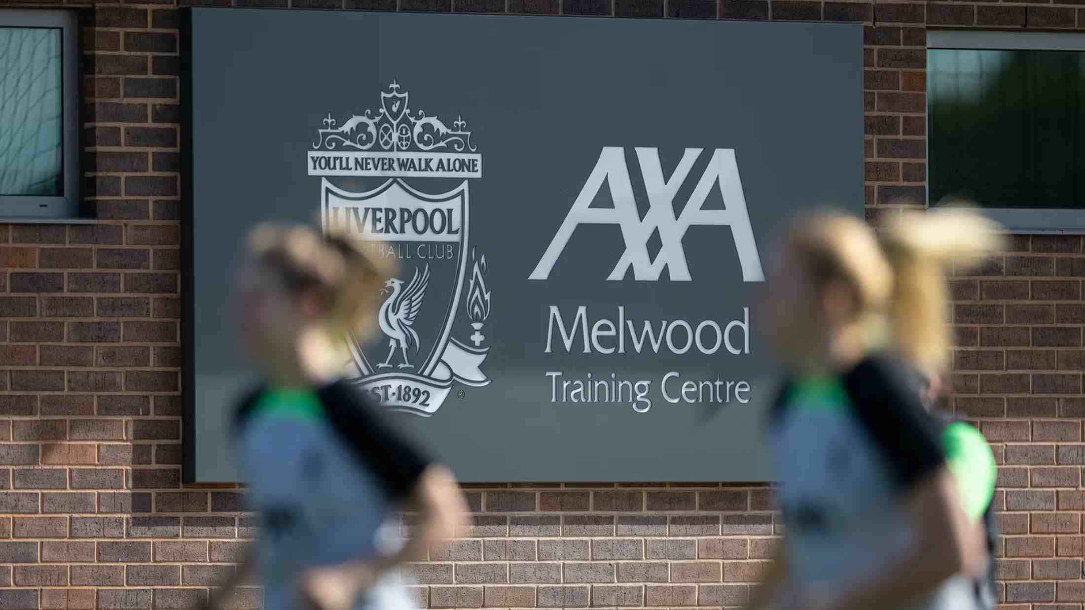 Liverpool Women's Football Club players training in front of AXA Melwood Training Centre sign