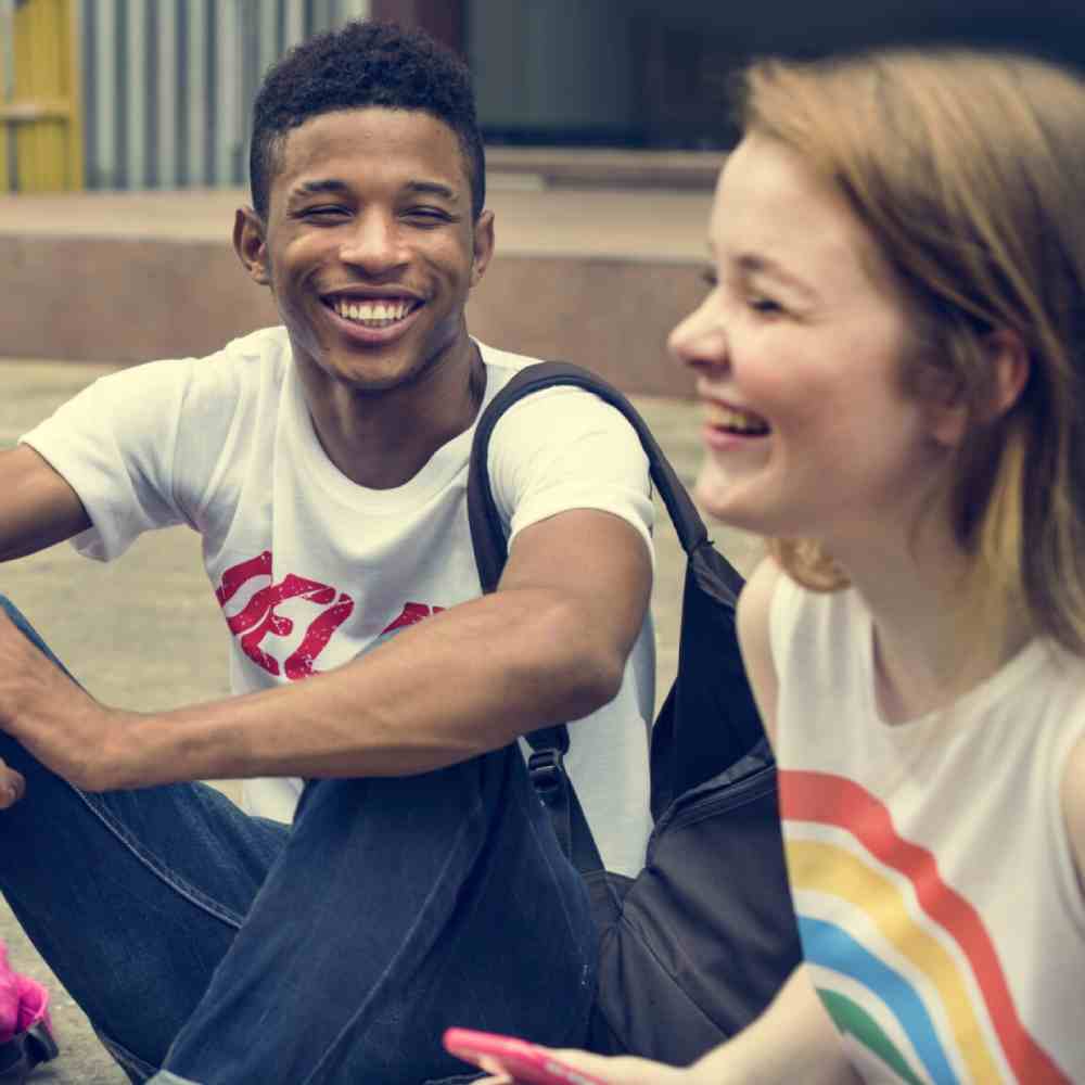 Two teenagers sat joking with one another