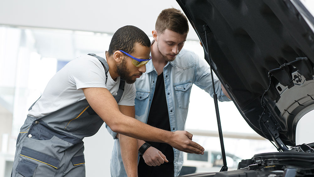 Mechanics inspecting car engine