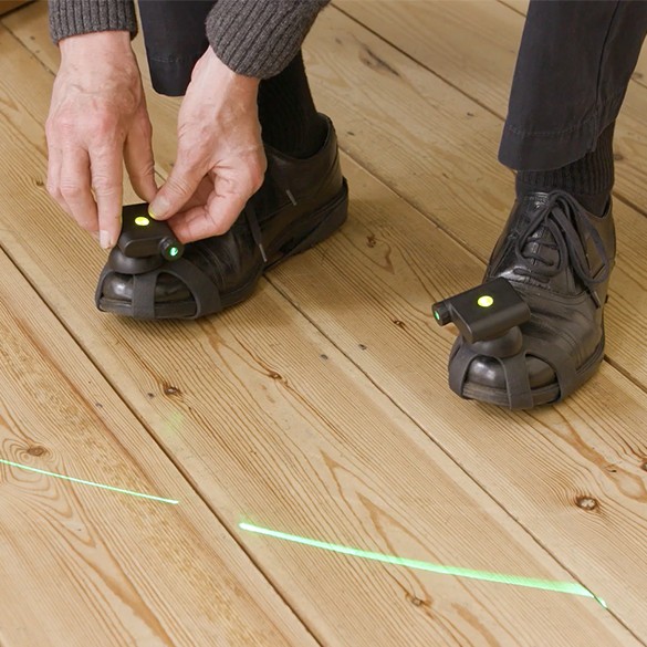 Man with Parinkson's wearing shoes with laser gadget attached for guidance