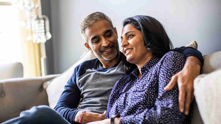 Husband and wife embracing on couch