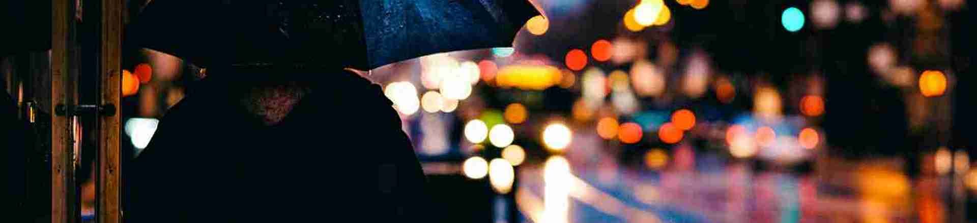 A silhouette of someone holding an umbrella.