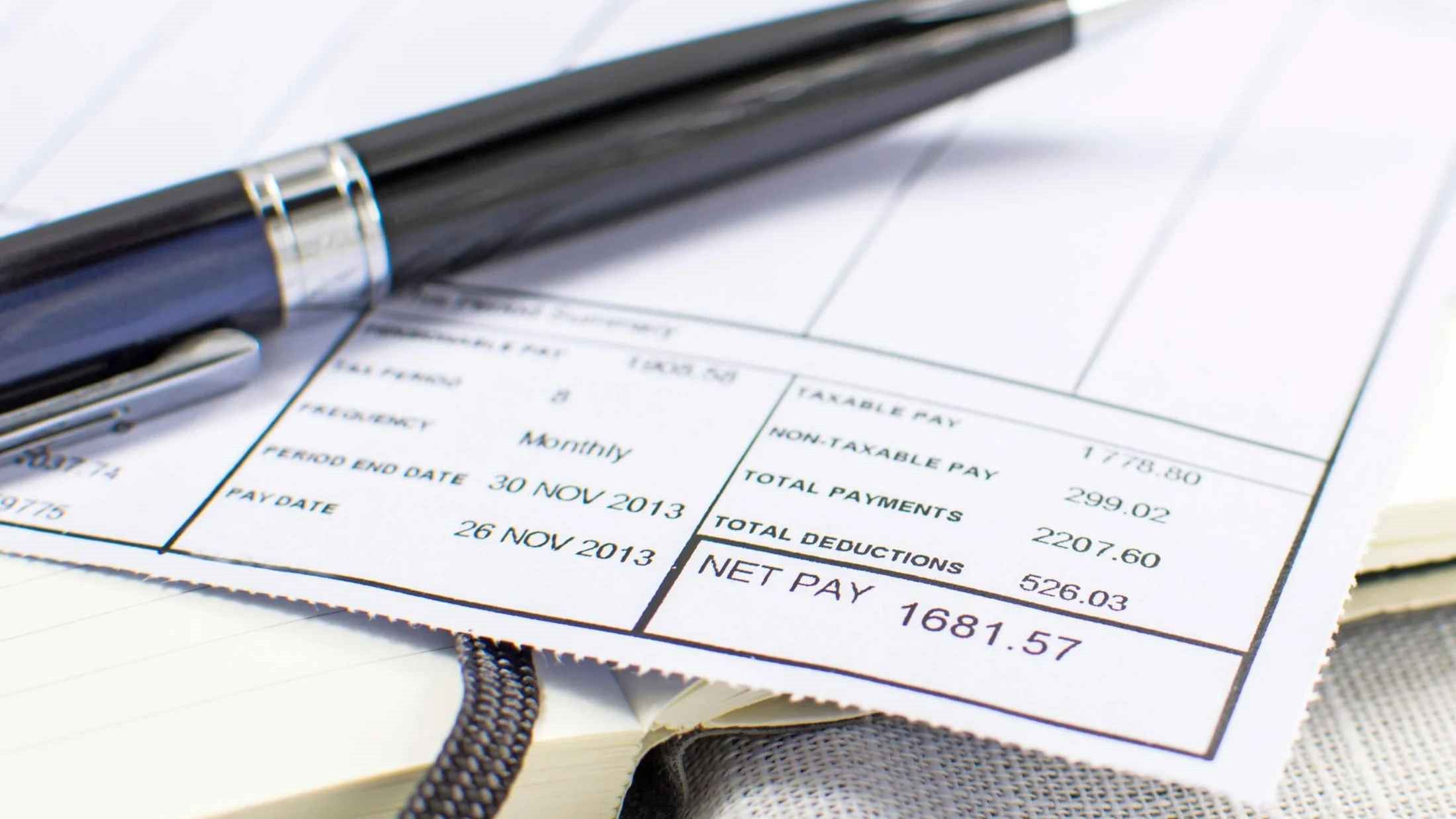 Pen resting on an employee's payslip