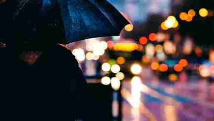 A silhouette of someone holding an umbrella.