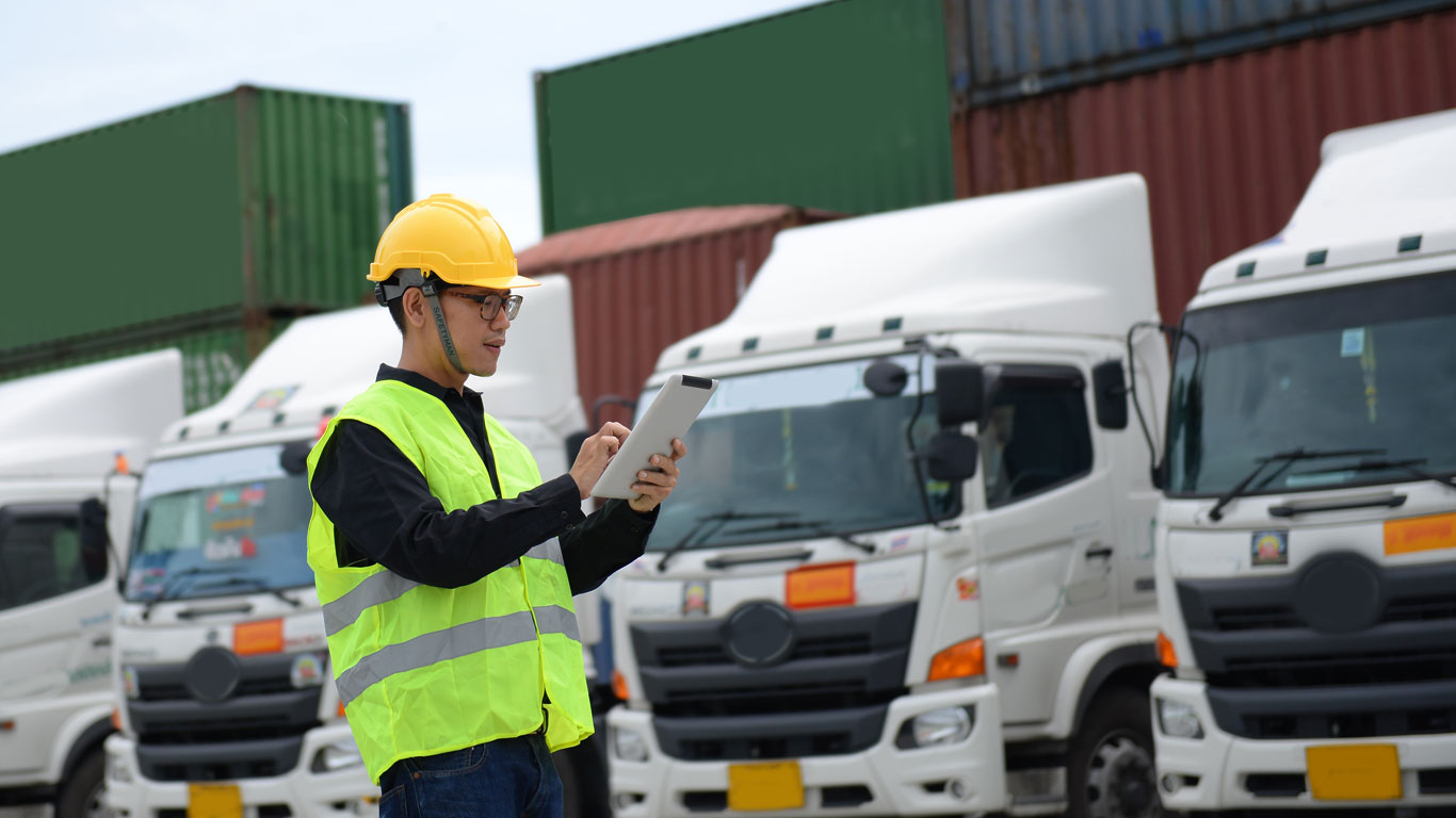 Person with PE equipment checking a fleet of trucks