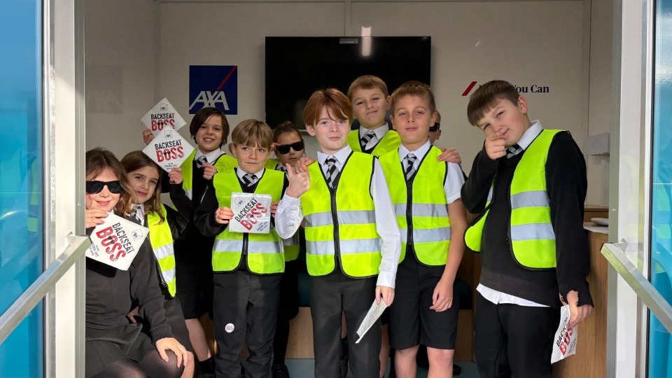 Students wearing hi-vis jackets stood inside the AXA Backseat Boss trailer at the Bournemouth Roadshow