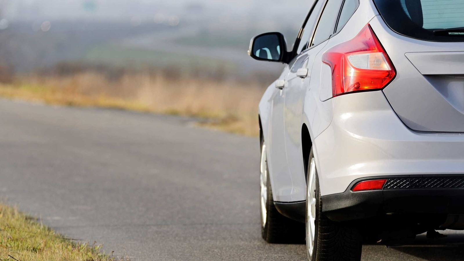 Grey car driving down country road