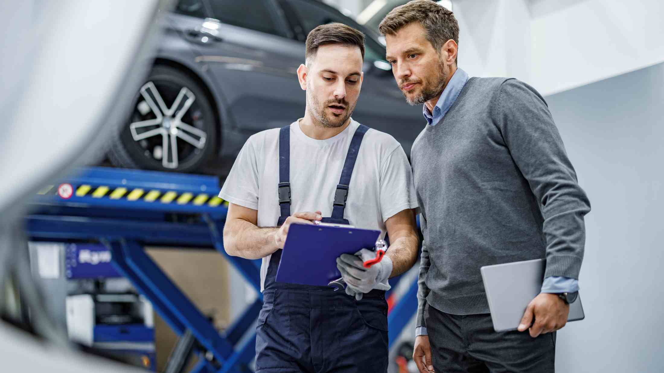 Auto mechanic and his manager working on documents in a repair shop