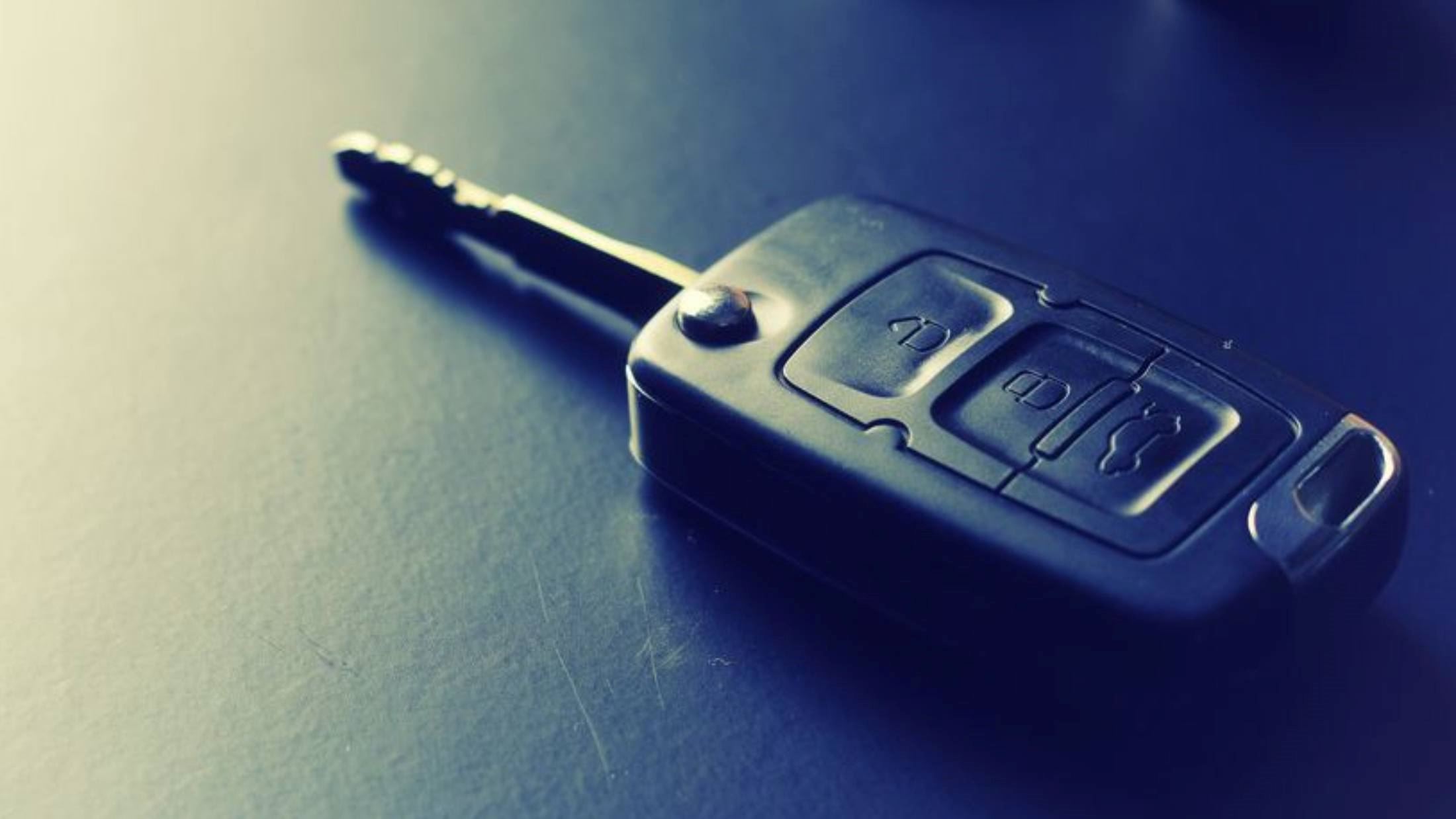 Black car key resting on a leather seat