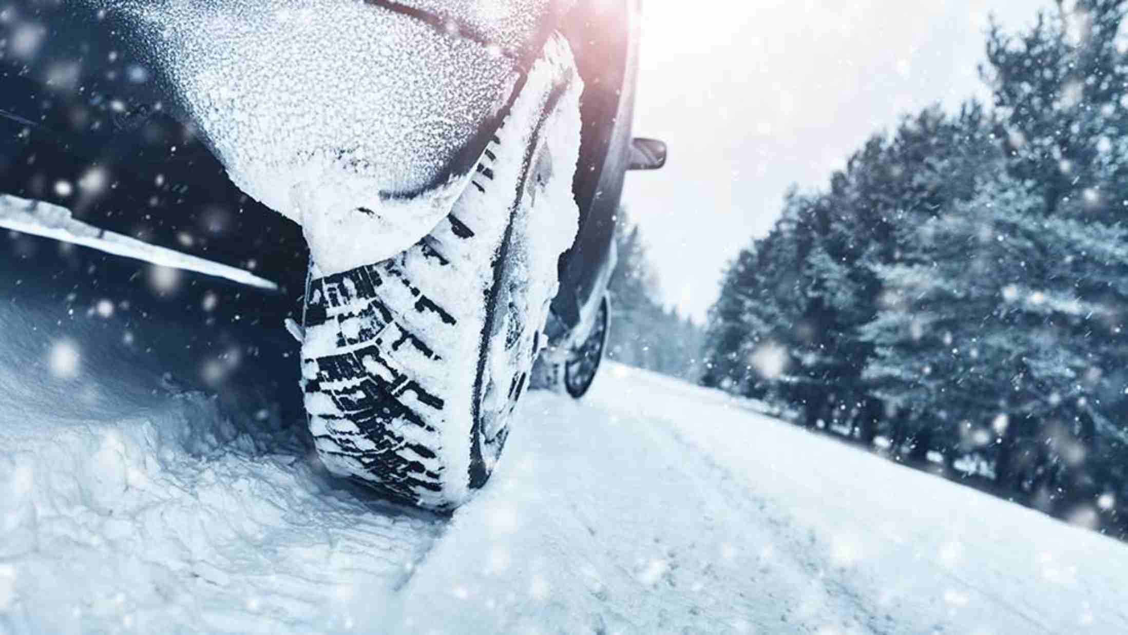 Close up of a car tyre on a road covered in snow