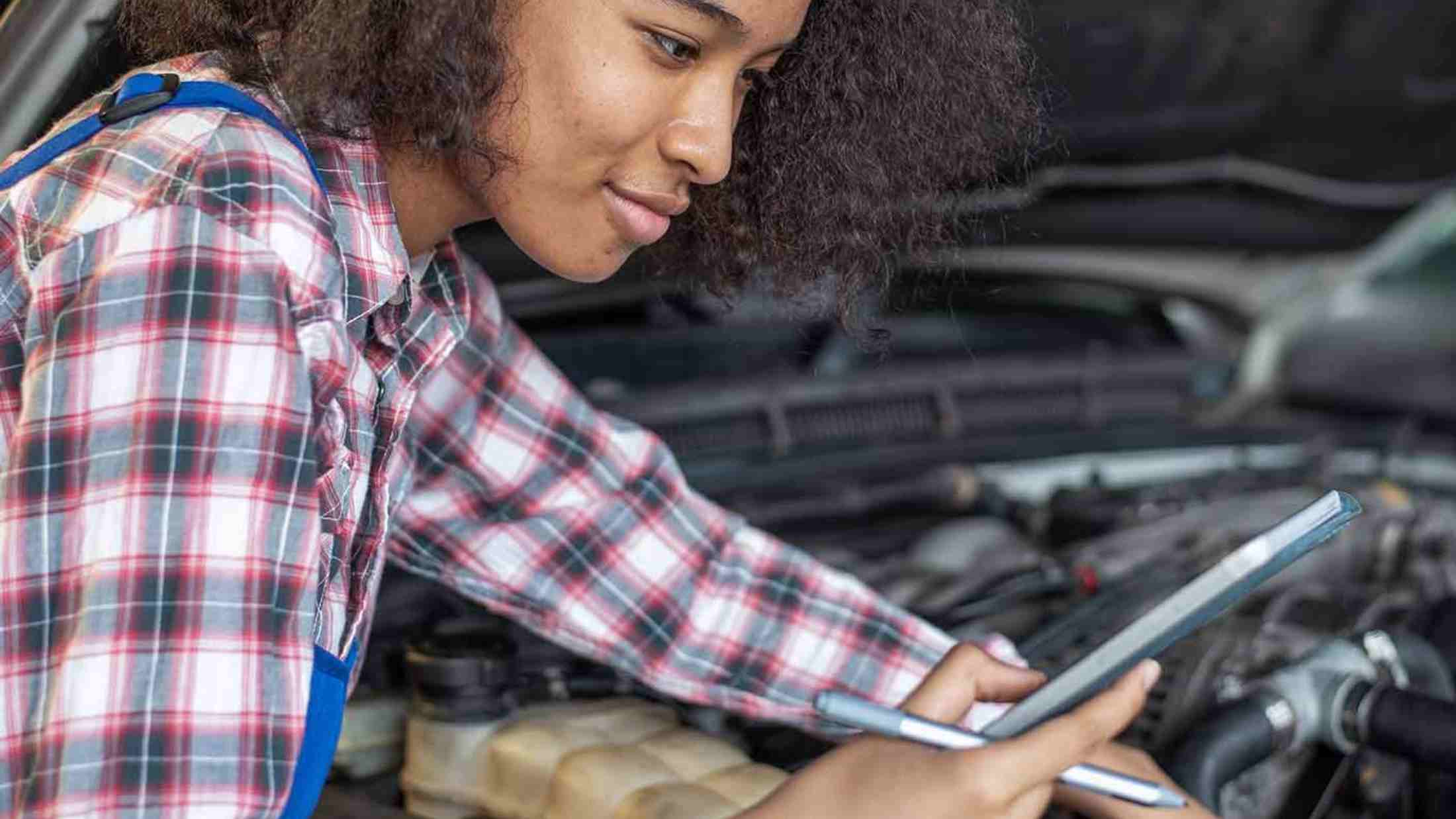 A female mechanic working on an engine