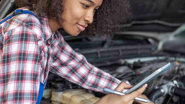 A female mechanic working on an engine