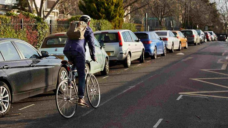 London cycle commuter riding away in neighborhood on way to work