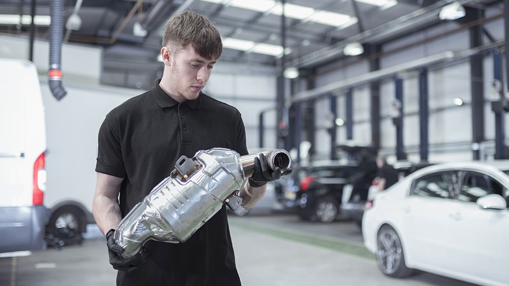 Mechanic holding a catalytic converter