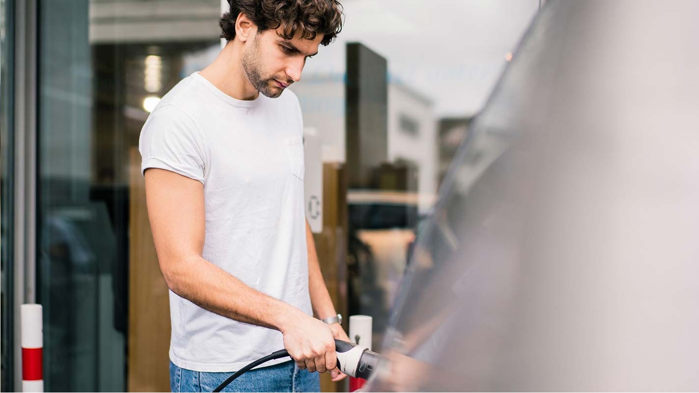 Man plugging charger into his electric car