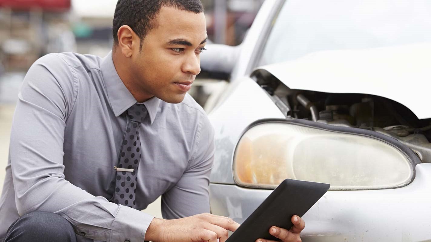 A man inspecting car crash damage