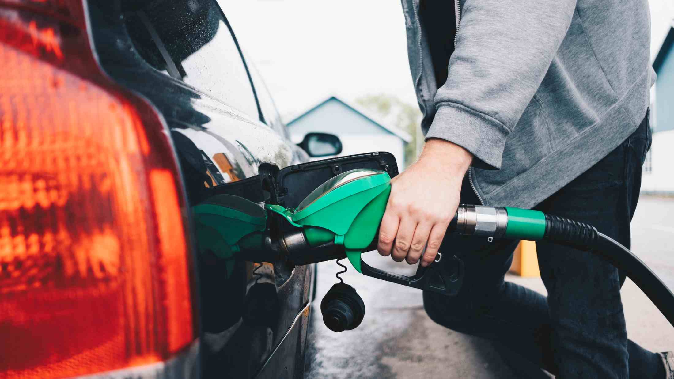 Midsection of man refueling car at petrol station