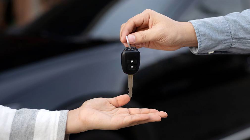 Car keys being exchanged between two people