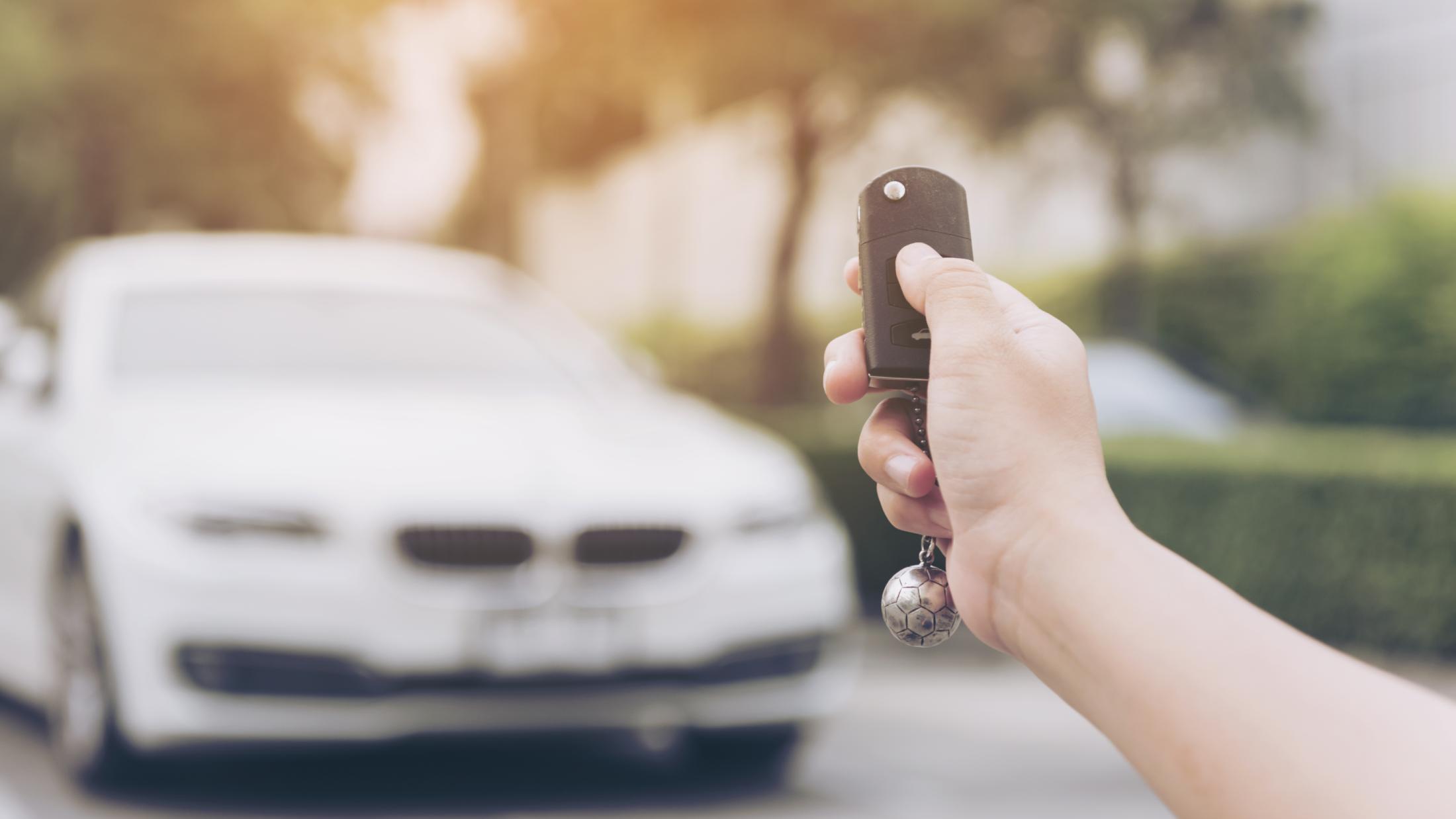 Person pressing unlock button on their car's wireless key fob