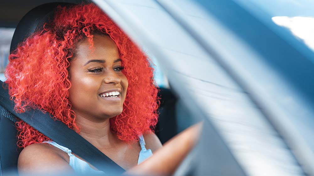 Girl with red hair behind the wheel of a car