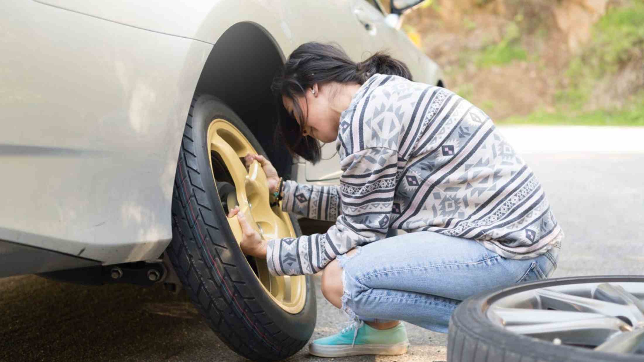 A female driver changing her car tyre