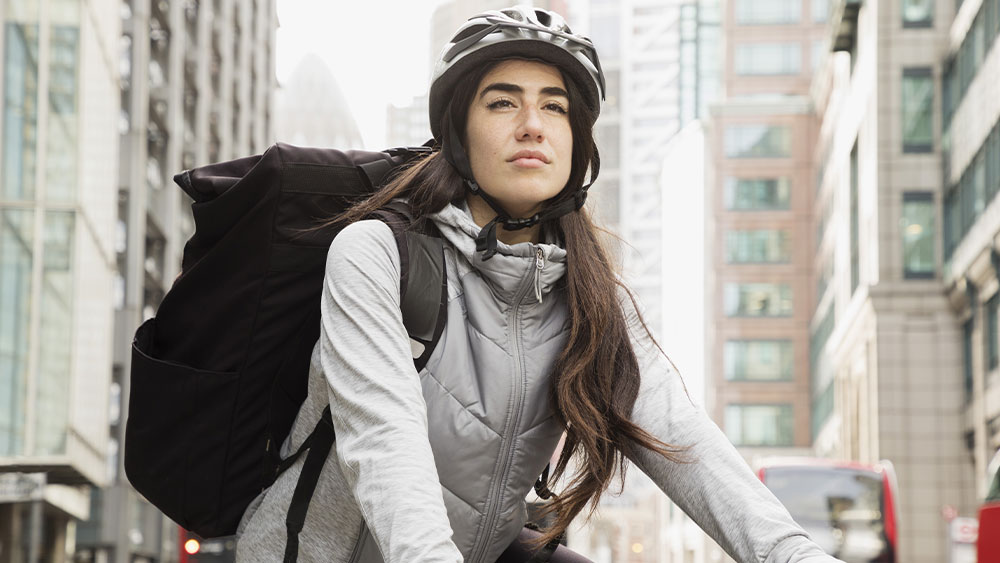 woman in a helmet is cycling in the city