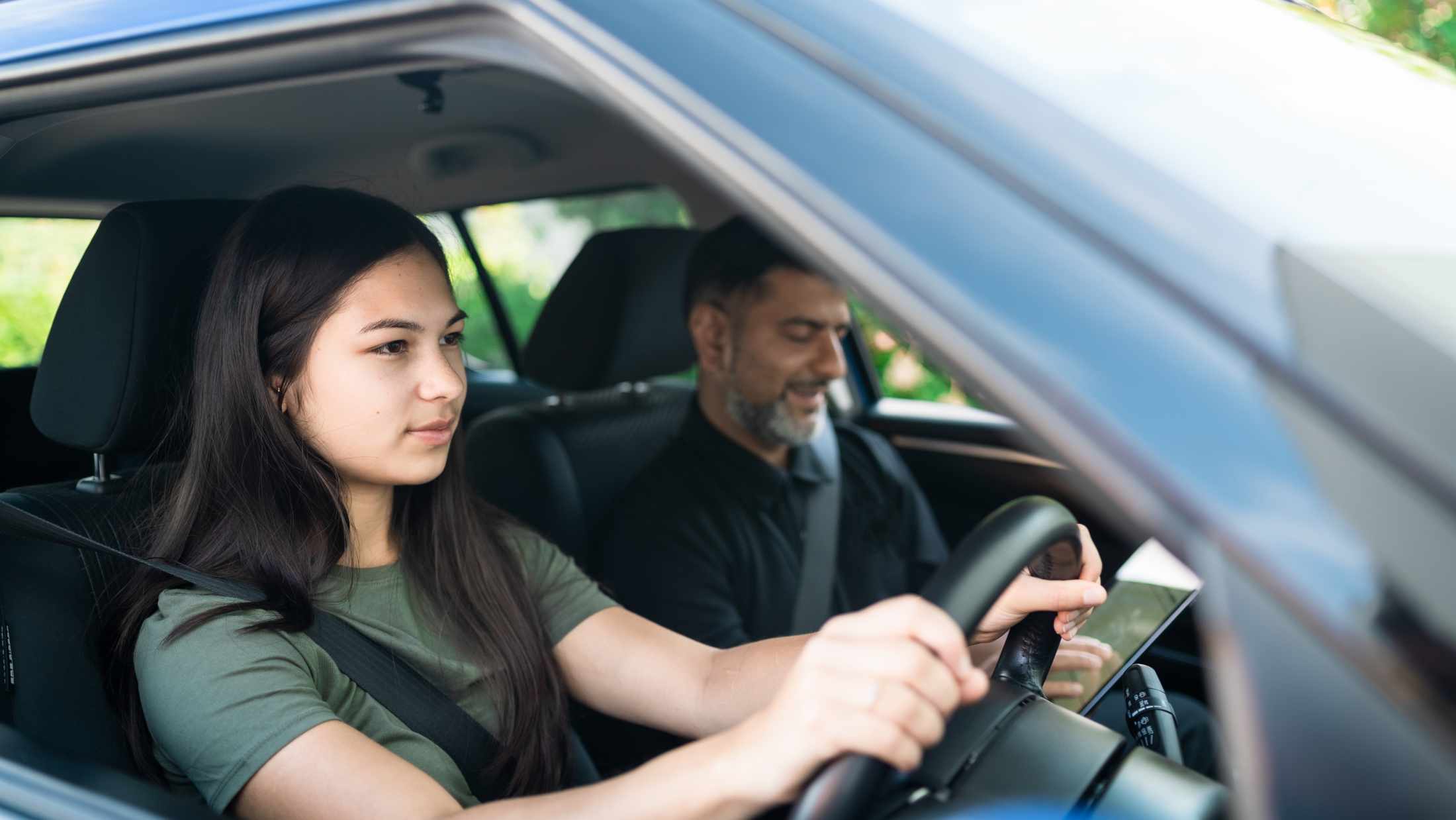 Young girl taking lessons for driving on the road