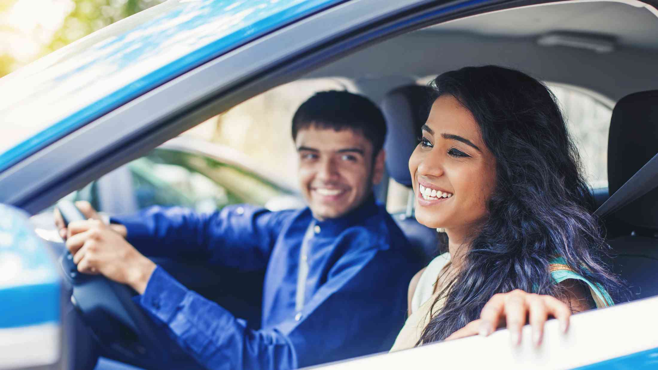 Young woman in a blue car being driven by an Indian man.jpg