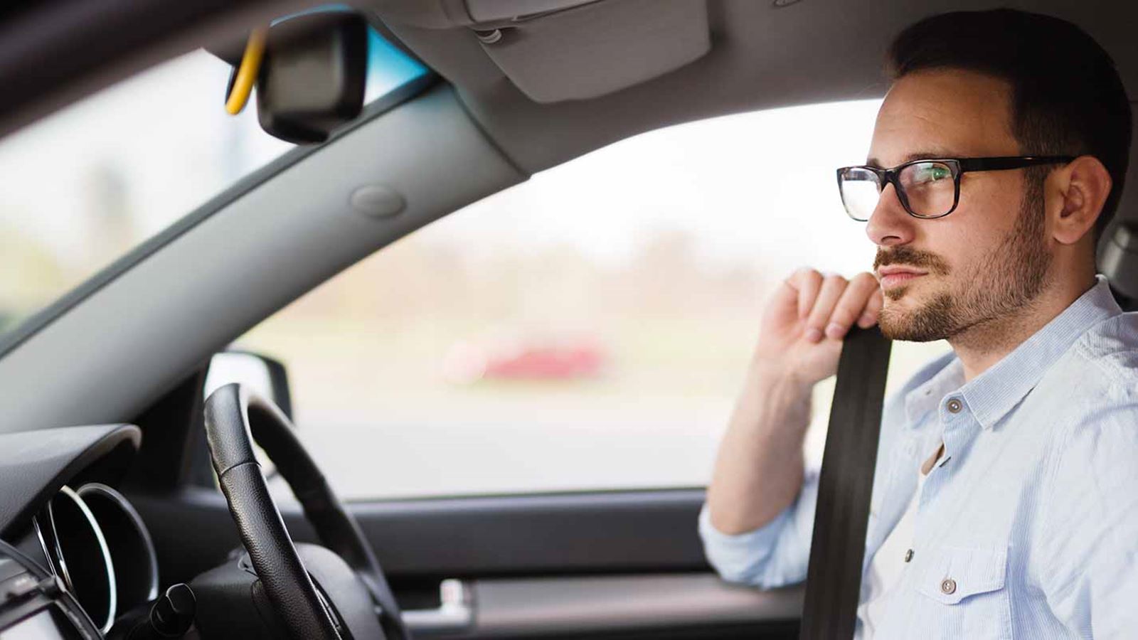 Young driver fastening his seatbelt