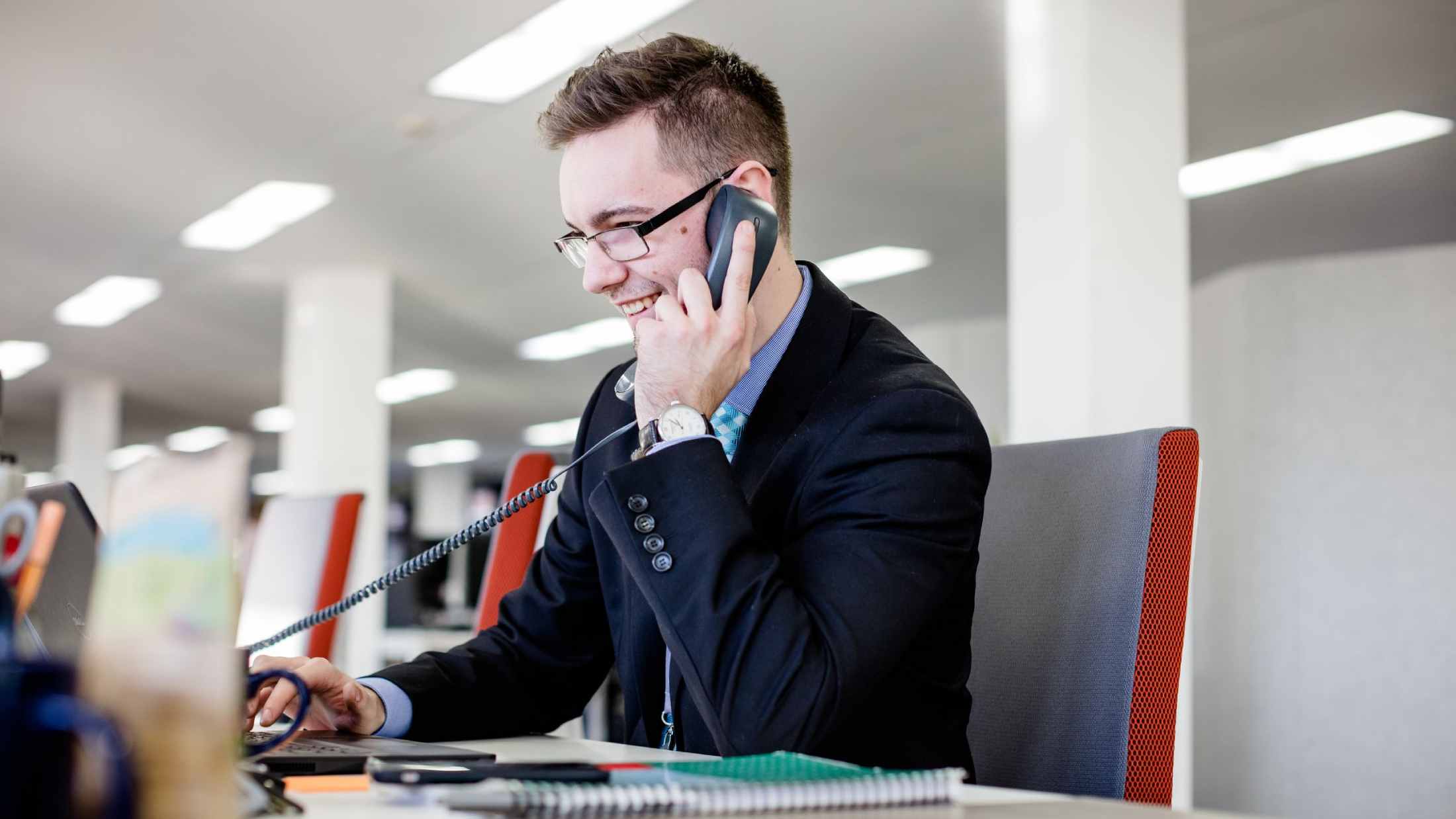 AXA employee on telephone while using his laptop