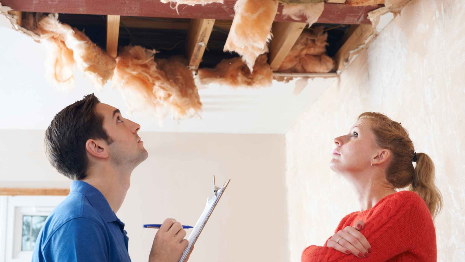 Male with clipboard and his client inspecting a partially collapsed roof