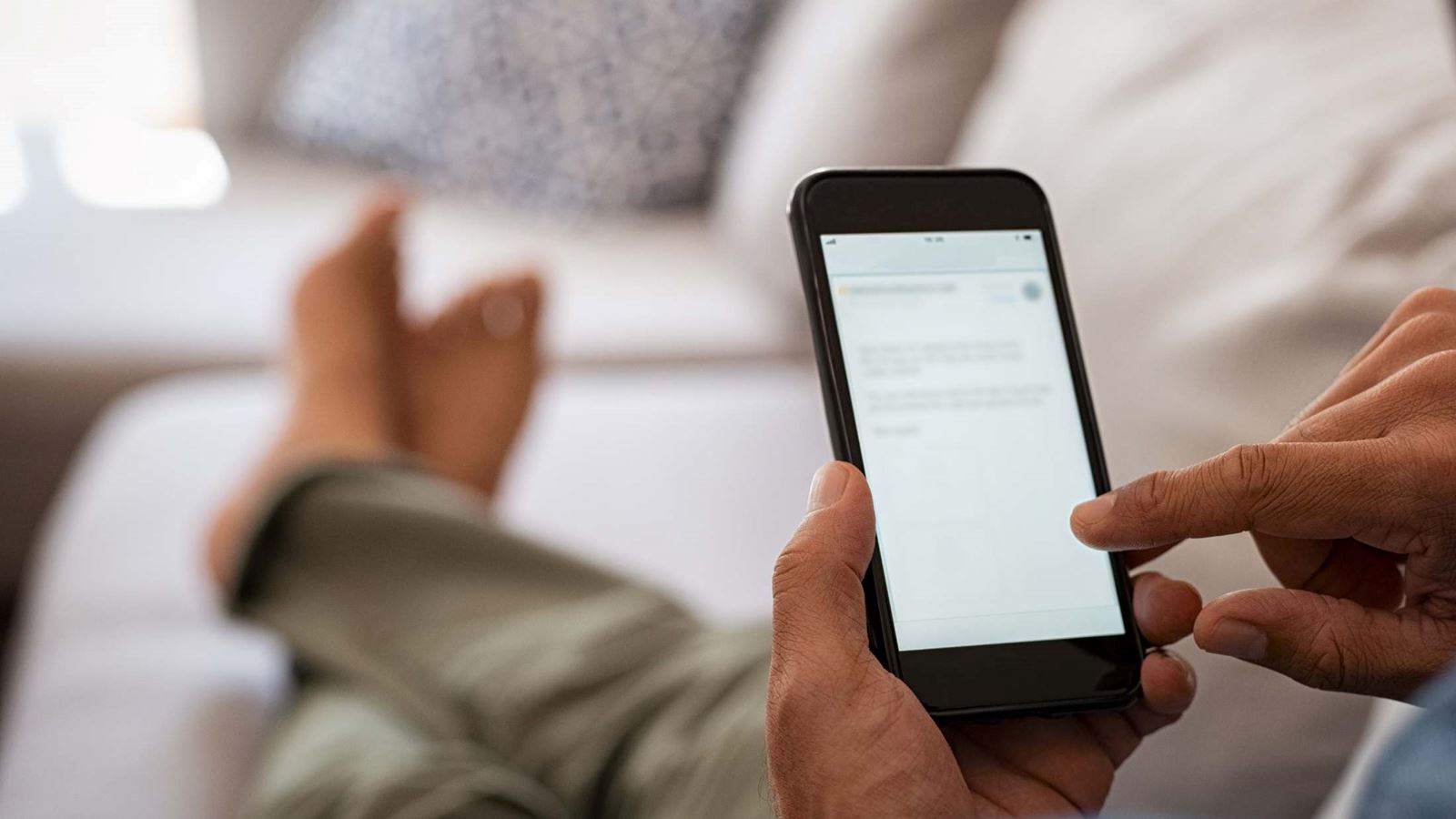 Closeup of a person holding a mobile phone while reading a document on the screen