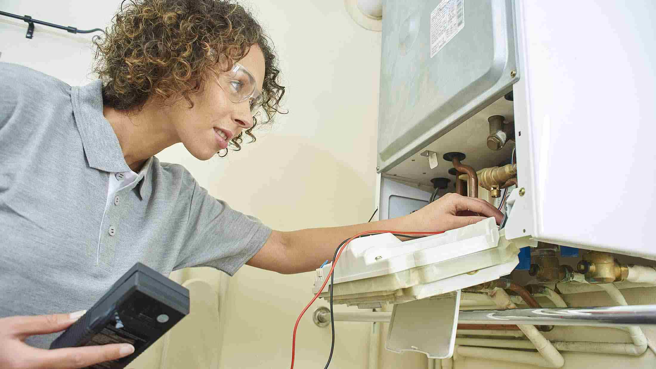 Female plumber fixing central heating