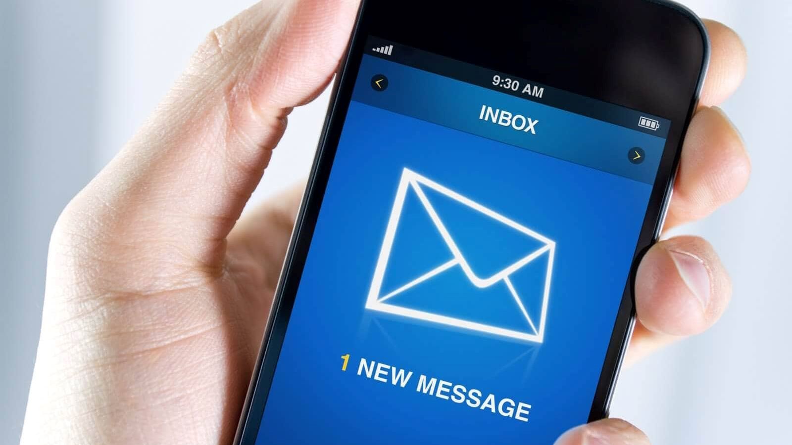 Hand holding a smartphone showing inbox with one new message