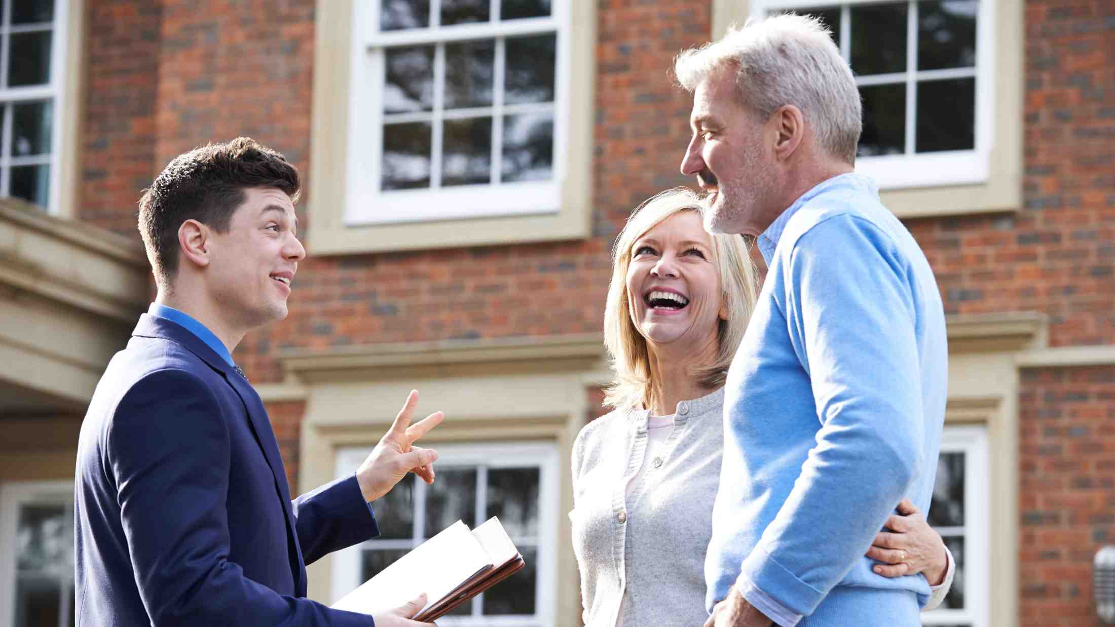 Man and woman with estate agent outside home