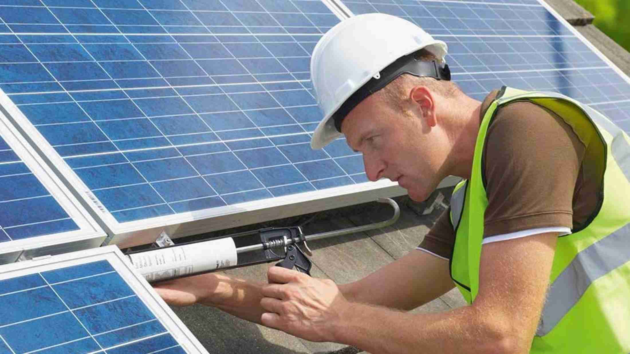 A man installing solar panel on a house roof