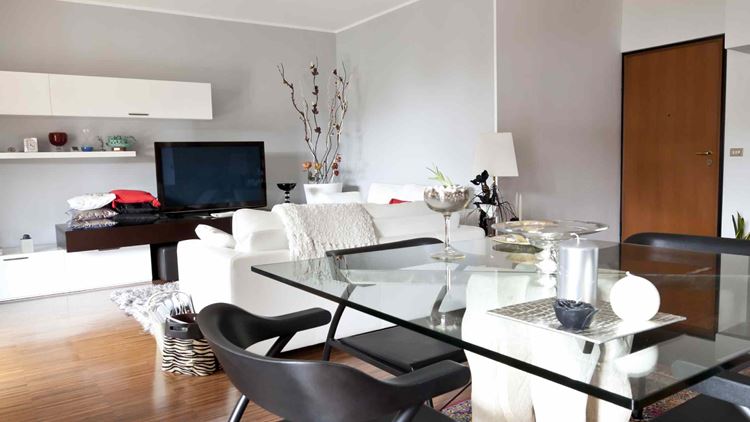 Modern living room with glass table, white sofa and television