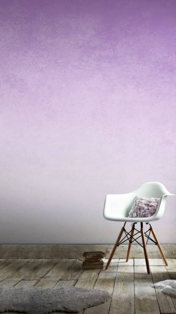 Ombre purple and grey effect on a wall with white chair in front of it