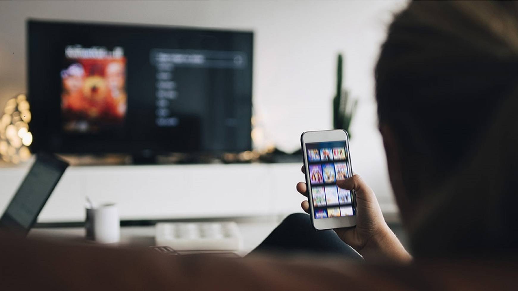 Woman settling down in front of TV to look at phone