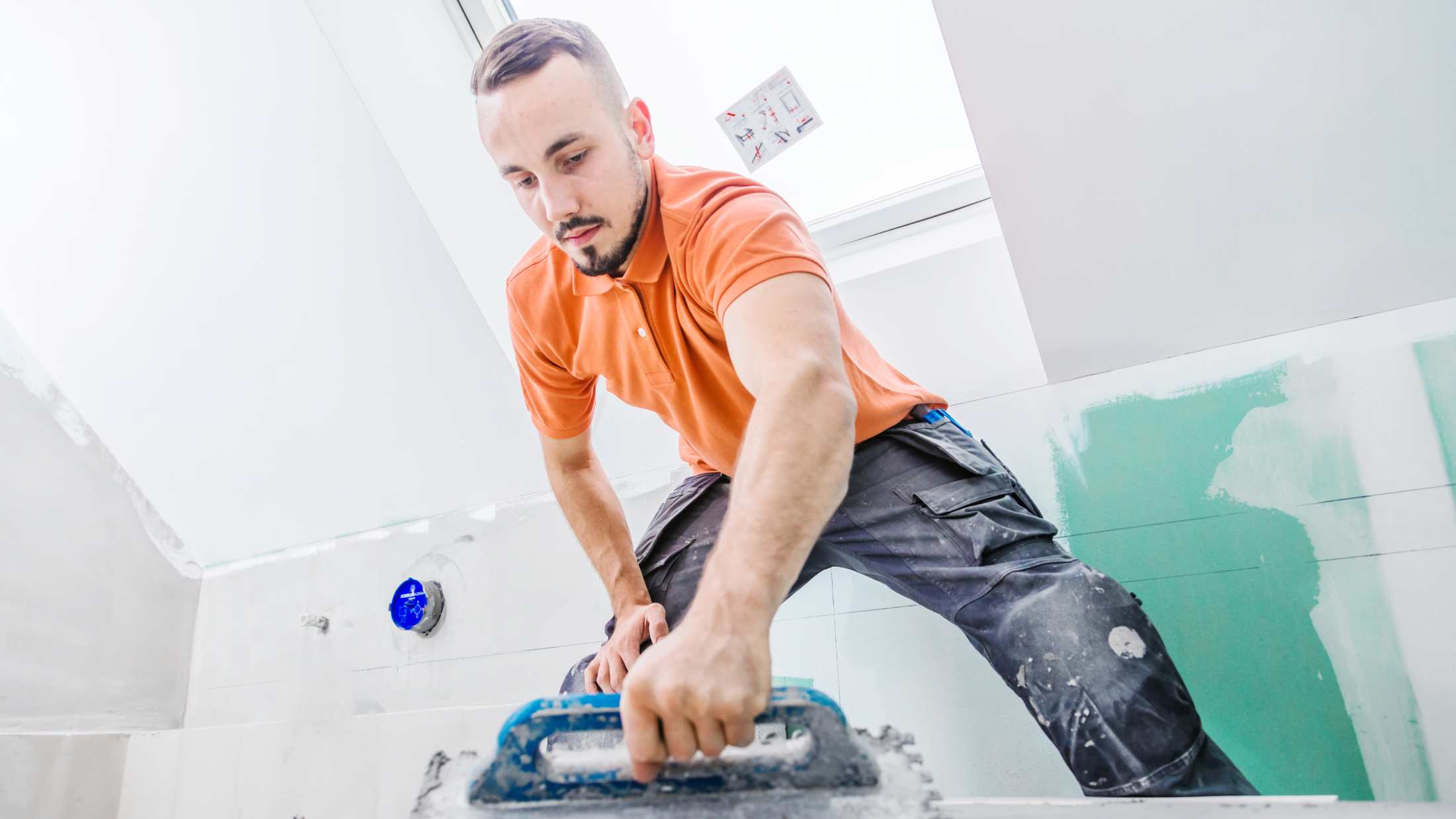 A man works in the bathroom of a modern house