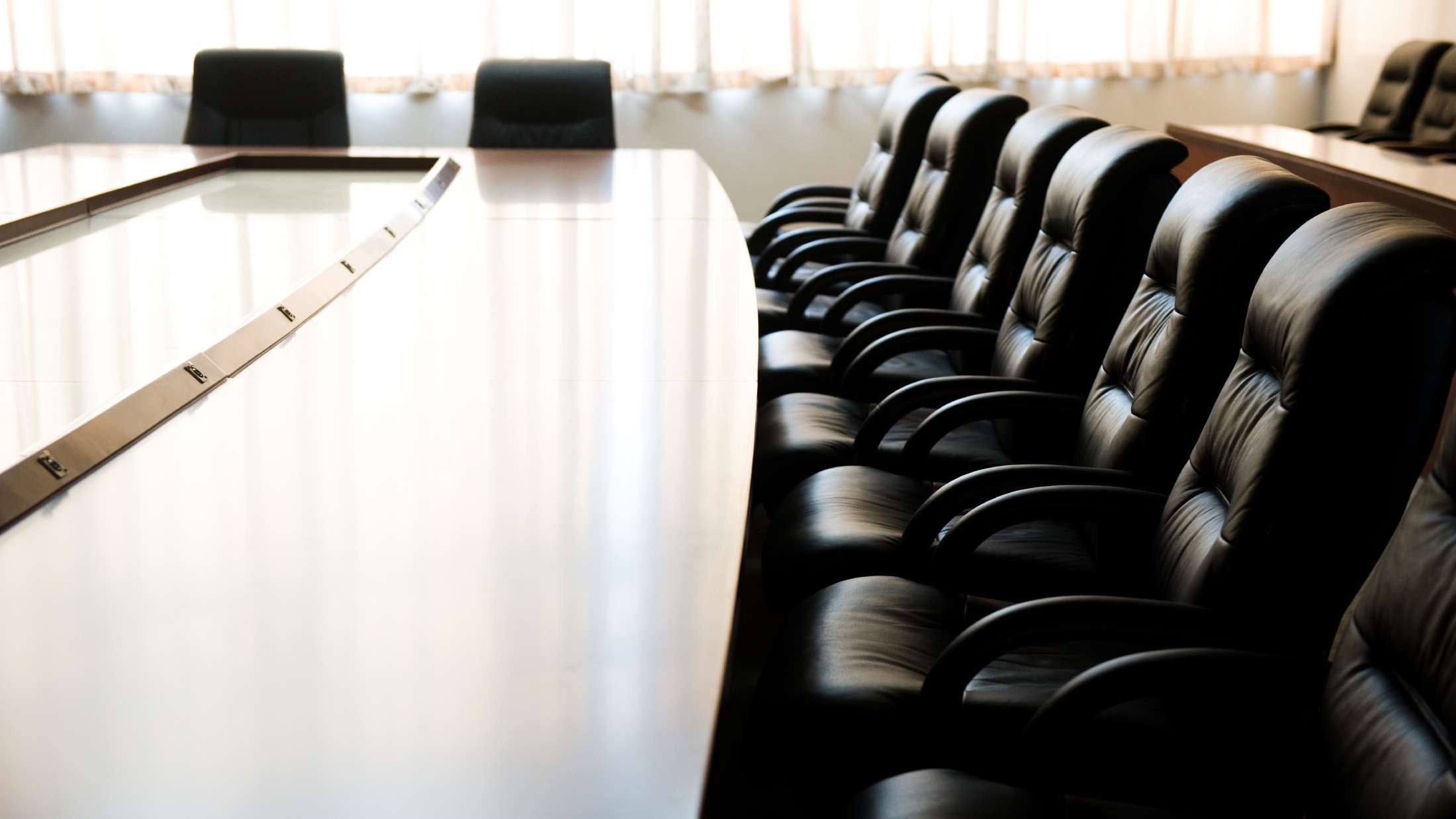 Business meeting room with large table and black chairs