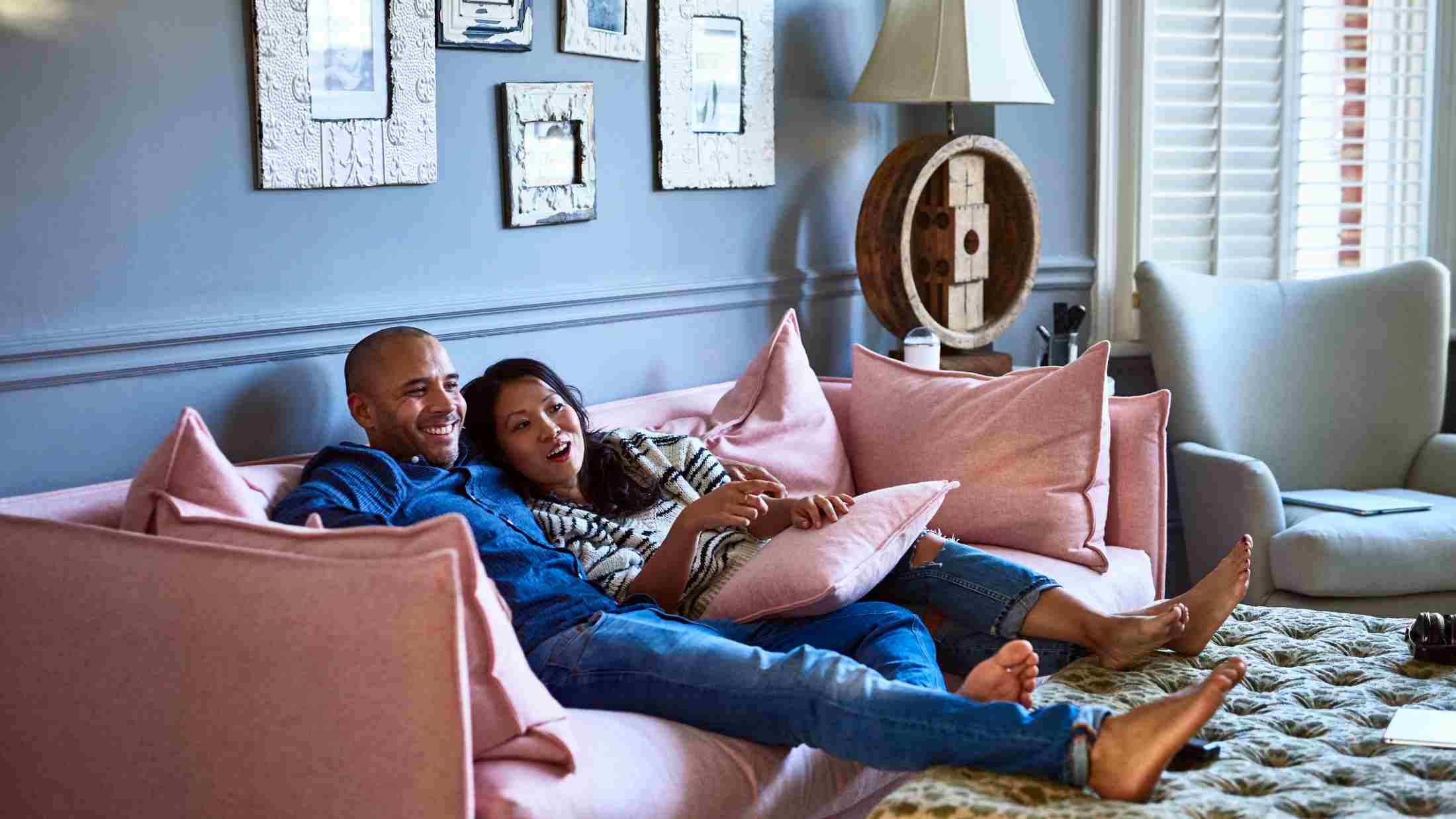 Couple at home watching television together on sofa